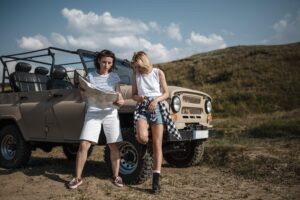 two female friends traveling by car checking map 300x200 